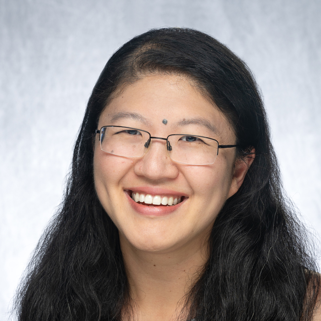 Photo of brunette with glasses wearing black & white polka dot top