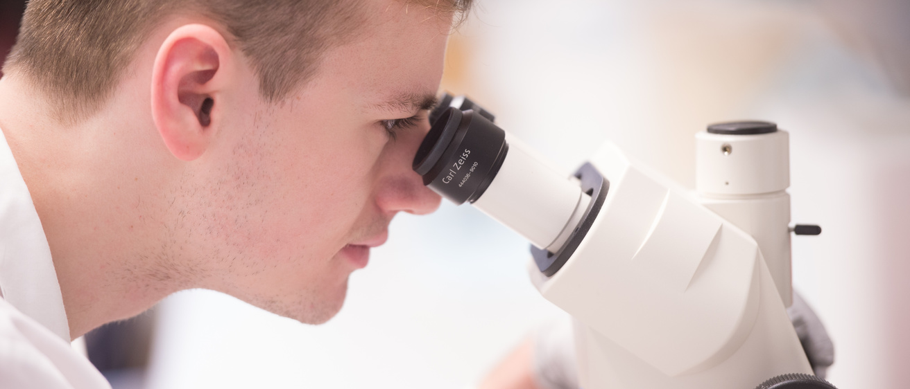 UI Scientist looking through microscope